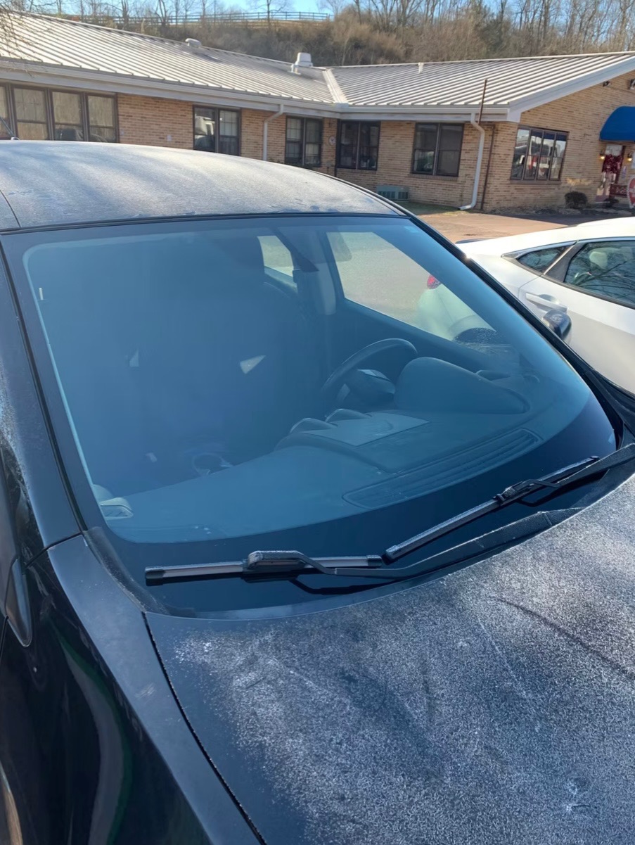 New windshield installed — dark sedan