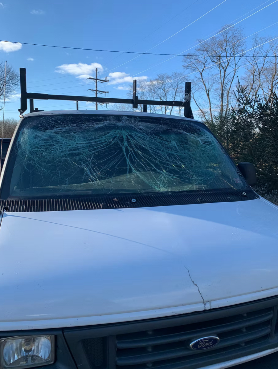 Shattered windshield — white Ford van
