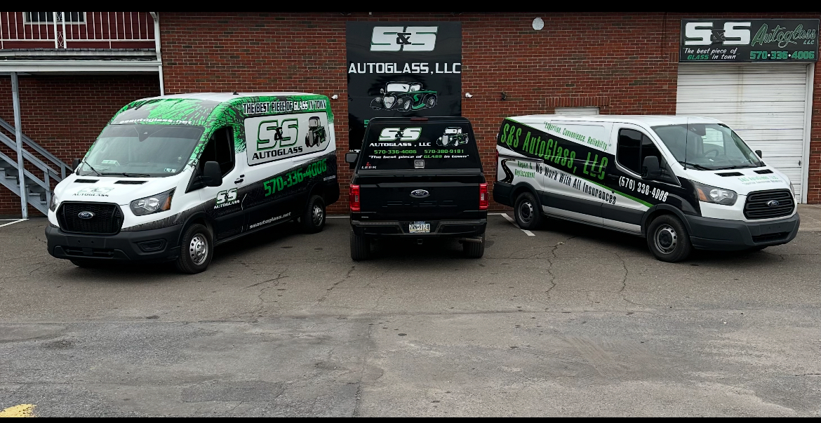 S&S AutoGlass fleet — two vans and truck in front of the shop